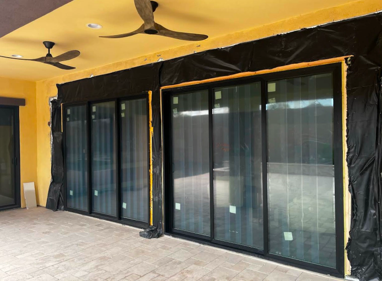 glass doors with black frames of a yellow walled house